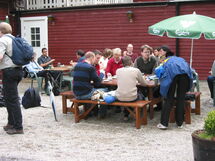 People drinking coffee around a table. Photo.