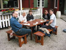 People drinking coffee around a table. Photo.